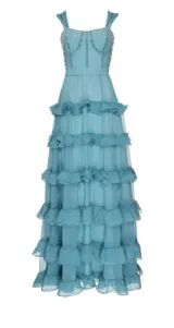 Vestido largo de fiesta color celeste, con tirantes finos, escote corazón y falda de tul con volantes. El corpiño está bordado con perlas y lentejuelas. Incluye copas integradas y cierre trasero invisible.