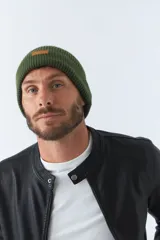 Gorro de lana azul marino con etiqueta de cuero con logo de la marca.