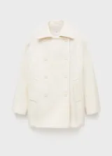 Abrigo blanco de lana virgen con diseño oversize, cuello de solapa y cierre de doble botonadura.