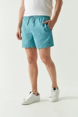 Short de baño celeste con estampado de hojas, cintura elástica con cordón ajustable, dos bolsillos laterales y uno trasero.