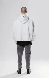 Hoodie gris claro de corte cropped, con capucha y cordones negros con texto blanco.