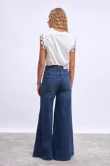 Pantalón de jean azul oscuro, modelo wide leg (pierna ancha) con tiro alto y cierre frontal de botones.