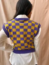 Chaleco tejido sin mangas con cuello redondo y estampado a cuadros grandes en color violeta y amarillo.