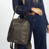 Mochila color beige de símil cuero con doble apertura superior con cierre. Incluye dos bolsillos al frente con cierres metálicos, asa rígida de mano y correa de galón. En la espalda correas de galón regulables.