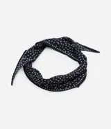 Pañuelo triangular de satén negro con lunares blancos.