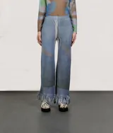 Pantalón de punto azul con diseño geométrico y flecos en el ruedo.