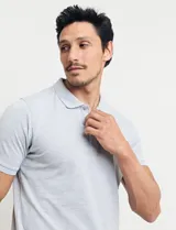 Chomba celeste de piqué con cuello clásico, tapeta de dos botones y mangas cortas. Tiene un pequeño logo bordado en el pecho. Corte clásico.