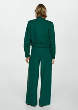 Chaqueta bomber verde esmeralda de lino y lyocell, con cuello redondo, cierre frontal con botones a presión, cintura y puños elásticos, dos bolsillos de parche con solapa en el pecho y corte cropped.