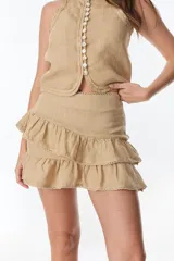 Minifalda color beige de lino con volados y detalle de puntilla en el ruedo.