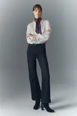 Pantalón de jean negro de tiro medio y calce ajustado desde la cintura hasta la rodilla, con pierna acampanada. Confeccionado en tejido confort con elastano, cierre y botón. Forrería estampada con logo de la marca.