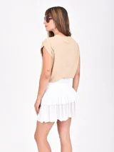 Falda corta blanca con volados y elástico en la cintura.