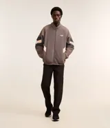 Saco masculino confeccionado en fleece color gris con recortes en marrón y negro, cuello alto, cierre en cremallera, cintura y puños ajustados con elástico. La prenda posee estampa localizada en el pecho con la palabra "LEAGUE".