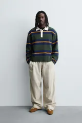 Polo de punto de corte relajado con diseño de rayas horizontales en tonos verde, azul y mostaza. Presenta cuello solapa en color crema a contraste y cierre frontal con tres botones.