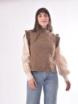 Chaleco tejido color beige con cuello alto y volados en los hombros. Diseño con patrón de rombos en relieve.