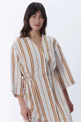 Vestido camisero midi con rayas verticales color camel sobre fondo blanco, cuello camisero y mangas 3/4.