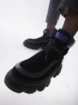 Botas de caña media color marrón de cuero gamuzado, con suela track y cordones rojos.