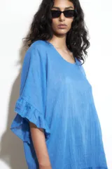 Túnica azul francia de corte holgado, con cuello redondo y mangas cortas con volados.