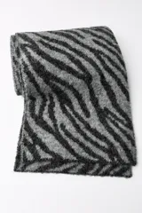 Bufanda rectangular de punto con estampado de cebra en tonos grises y negros.