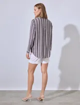 Camisa con estampado a rayas en blanco y negro, con cuello tipo solapa y escote en V.