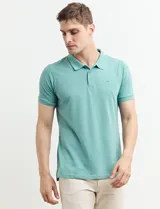 Chomba celeste con estampado de lunares blancos, cuello clásico y mangas cortas.