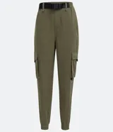 Pantalón jogger color verde militar, con cintura elástica ajustable con cinturón de hebilla plástica. Tiene bolsillos laterales tipo cargo con fuelle y puños elásticos.