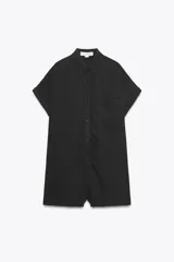 Mono corto negro de tejido fluido, con cuello solapa, manga corta con vuelta, bolsillo de plastrón en el pecho y cierre frontal con botones.