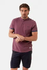 Remera de manga corta color azul grisáceo con cuello mao y tapeta de botones. Los puños de las mangas y el cuello son de color azul marino contrastante. Presenta un pequeño logo bordado en el pecho.