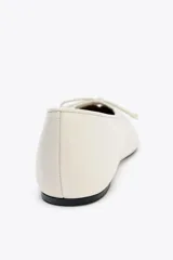 Zapato tipo bailarina color crema, de piel efecto soft, con detalle de lazo en la parte delantera y acabado en punta redonda.