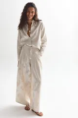 Conjunto color crema con estampado floral, compuesto por una camisa de mangas largas y un pantalón culotte de tiro alto.