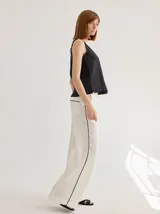 Pantalón de lino azul con corte palazzo y vivos a contratono color beige en los laterales.