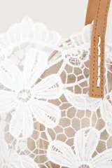 Bolso tipo shopper de encaje blanco con diseño floral, forro color beige y asas de cuero color camel.