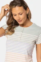 Remera de manga corta con cuello redondo y botones personalizados. Diseño a rayas horizontales en azul, blanco y rosa.