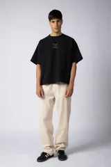 Pantalón de lino y algodón color beige claro, de calce suelto y tiro medio/alto con cintura elastizada y cordón regulable. Posee bolsillos laterales y un bolsillo trasero con tapa.