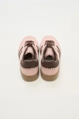 Zapatillas deportivas color rosa con detalles en marrón, cordones marrones y suela color caramelo.