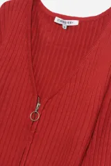 Sweater rojo de tejido de punto acanalado, con escote en V y cierre frontal con cremallera circular.