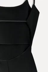 Vestido midi negro de breteles finos, escote recto y falda ajustada con abertura lateral.