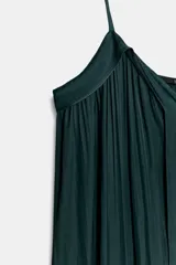 Vestido midi color morado oscuro, con escote en V y tirantes finos. El tejido presenta un acabado satinado y un efecto plisado o arrugado que le da fluidez.