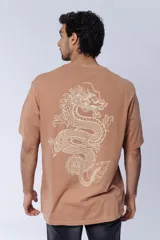 Remera color camel, corte oversize, con cuello redondo y estampado pequeño con la palabra 'Dragon' en el pecho.