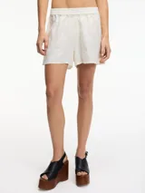 Short color crudo de lino con tiro medio, pretina elástica y bordado en los laterales.