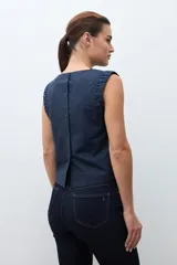 Blusa roja sin mangas, con cuello redondo y sisa drapeada.