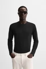 Camiseta negra de manga larga y cuello redondo, corte slim fit.
