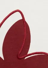 Remera blanca de algodón con estampado de una flor roja en el frente.