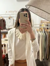 Cuello desmontable tejido a crochet en hilo de algodón color crudo, con borde festoneado.