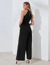 Enterito largo de crepe color rojo, con escote halter anudado y pierna ancha. Presenta bolsillos delanteros y abertura en la espalda con cierre invisible y botón.