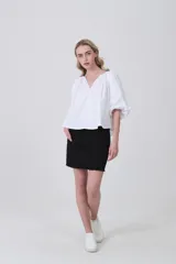 Blusa blanca de algodón con escote en V y frunces en el cuello, mangas abullonadas cortas y calce holgado.