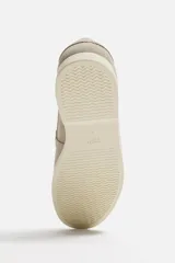 Mocasín casual color beige claro, con capellada de cuero serraje, corte liso con detalle de bordón y suela a contraste.