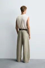 Pantalón de jean blanco, corte holgado y amplio en toda la pierna, tiro medio, tejido ligero, cinco bolsillos, efecto lavado y cierre frontal con cremallera y botón.