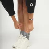 Pulsera de hilo elástico negro con dije central de corazón plateado de forma irregular y cierre tipo imán plateado.