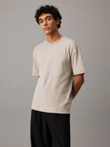 Remera color beige de algodón con logo de Calvin Klein bordado en el pecho.