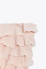Top palabra de honor color rosa claro, confeccionado en tejido texturizado con volantes en el frente.